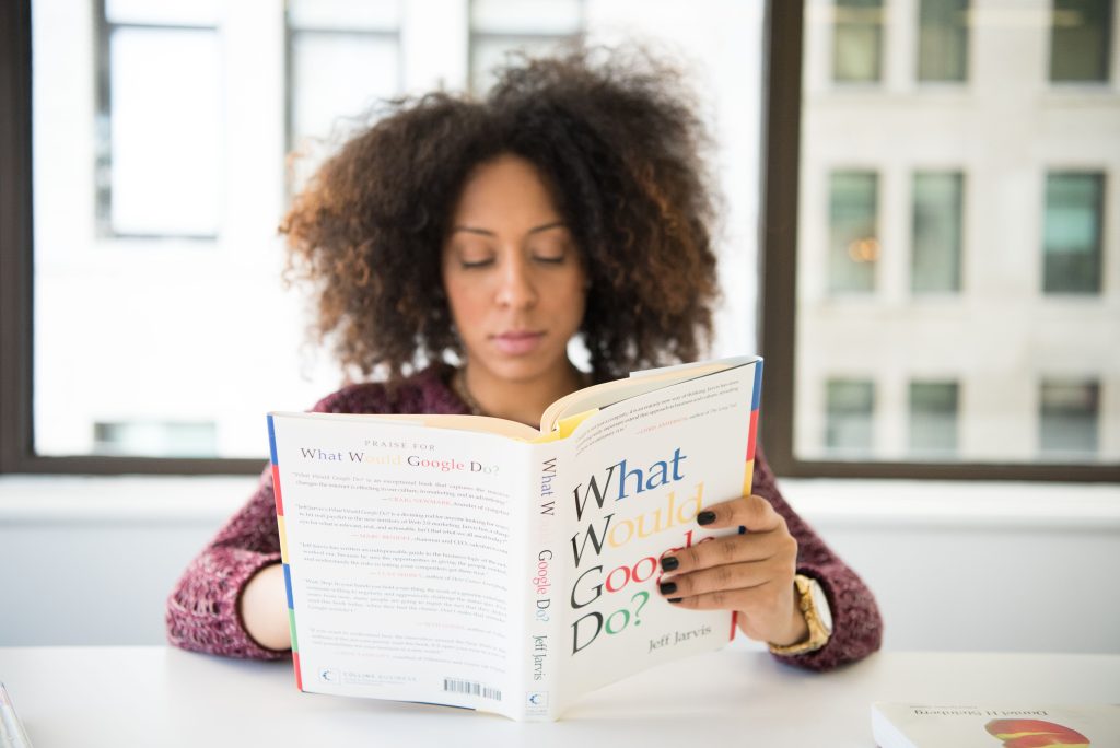 Vrouw leest geconcentreerd bij het raam