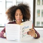 Vrouw leest geconcentreerd bij het raam