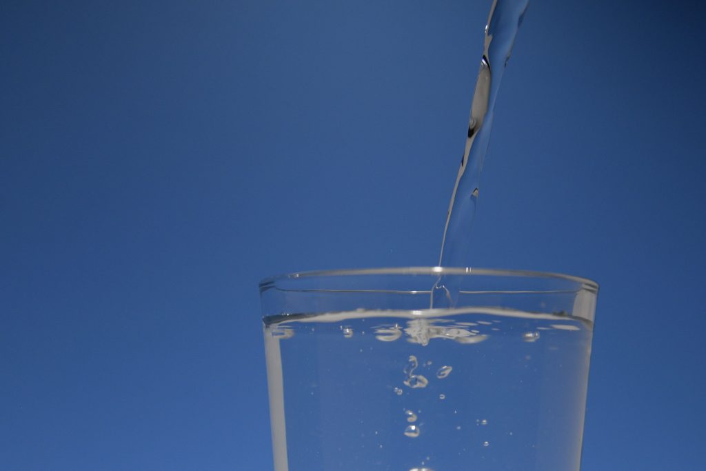 Water wordt voorzichtig in een glas gegoten