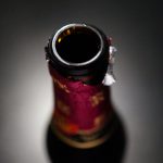 Close-up van geopende wijnfles met donkere achtergrond