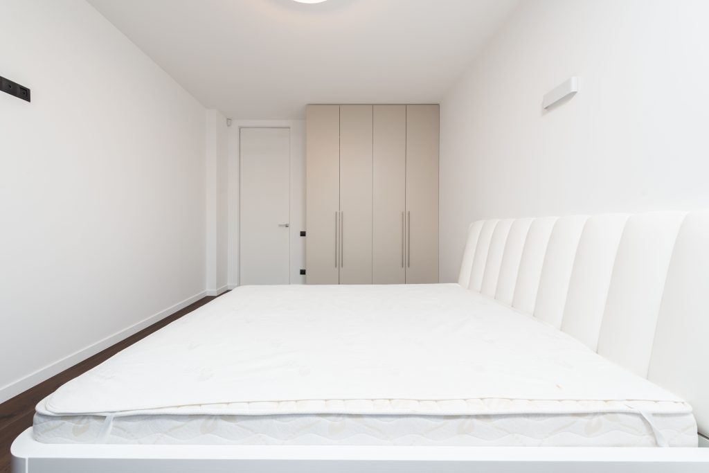 minimalistische slaapkamer met wit matras en kasten