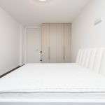 minimalistische slaapkamer met wit matras en kasten