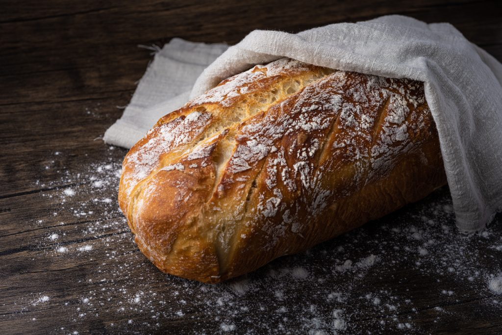 vers brood afgedekt met doek op houten tafel