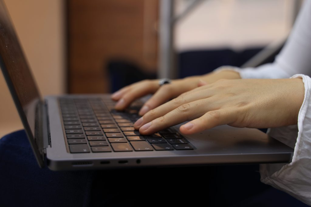 handen typen op een laptoptoetsenbord binnenshuis