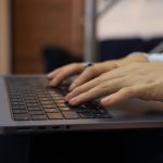 handen typen op een laptoptoetsenbord binnenshuis