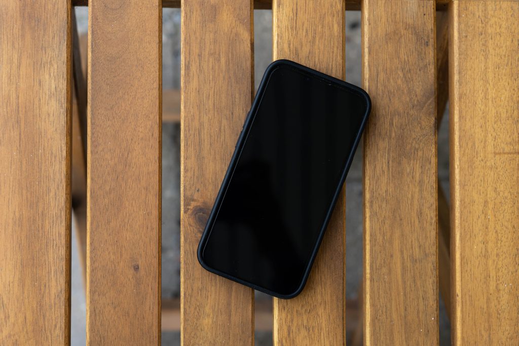 smartphone met zwart scherm op houten tafel