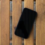 smartphone met zwart scherm op houten tafel