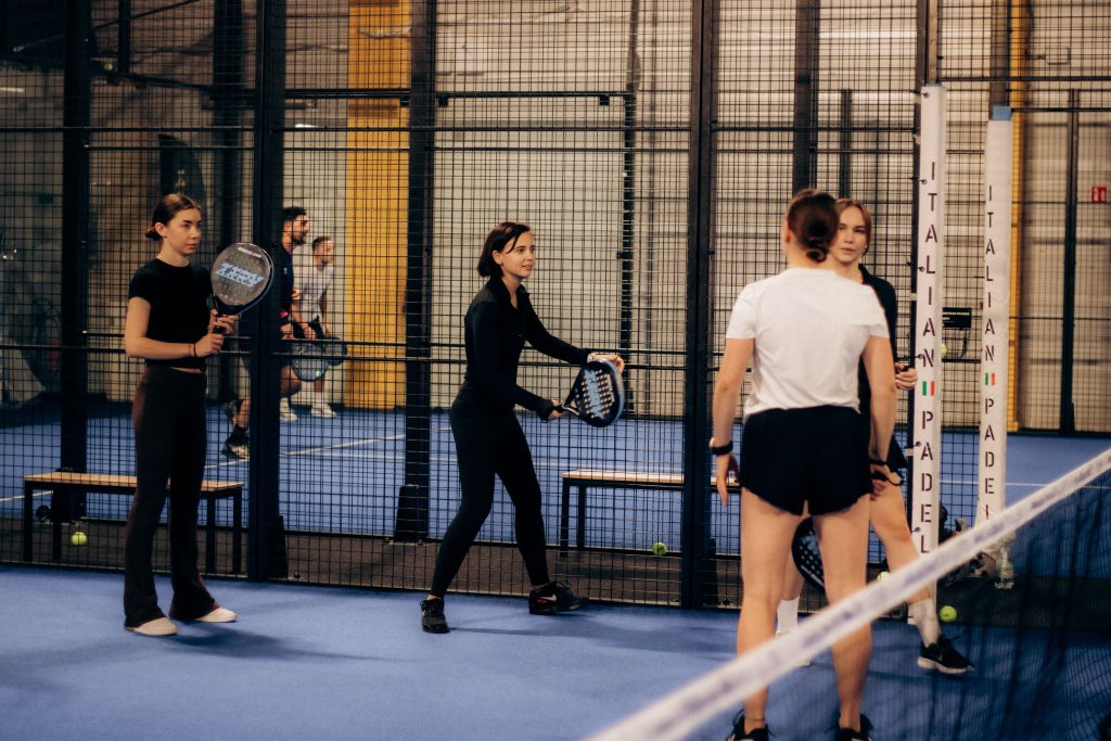 Groep speelt padel binnen op indoorbaan