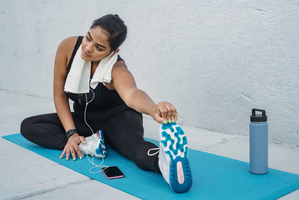 Vrouw stretcht op yogamat buiten na training