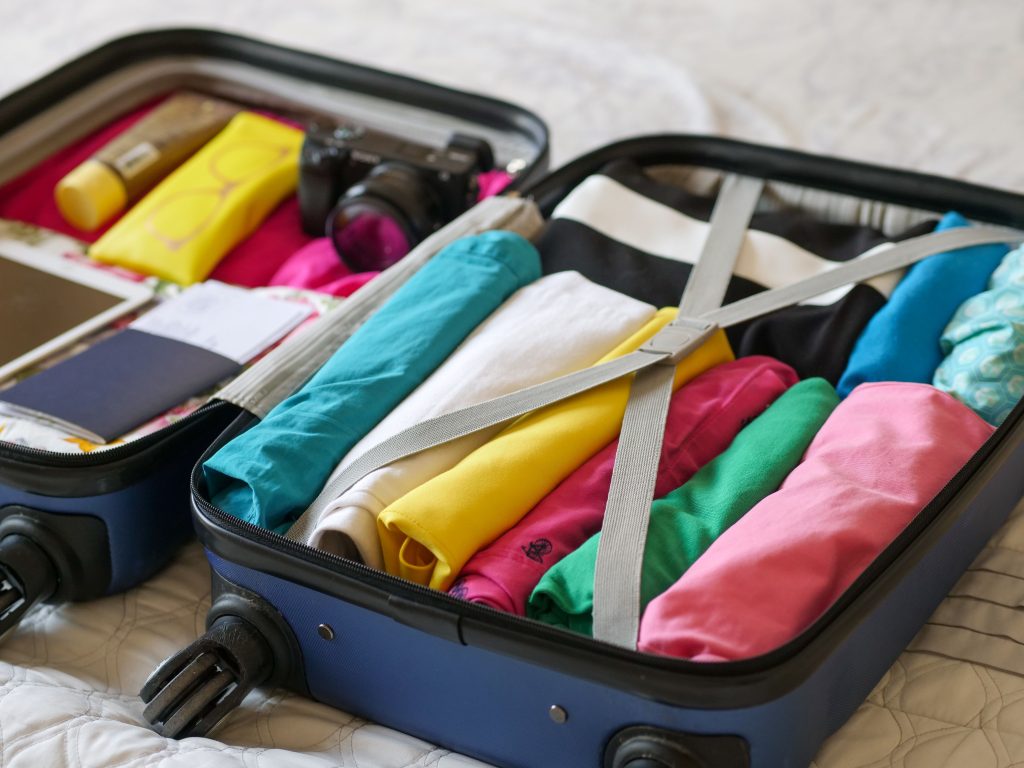Open koffer netjes gevuld met kleurrijke kleding