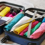 Open koffer netjes gevuld met kleurrijke kleding